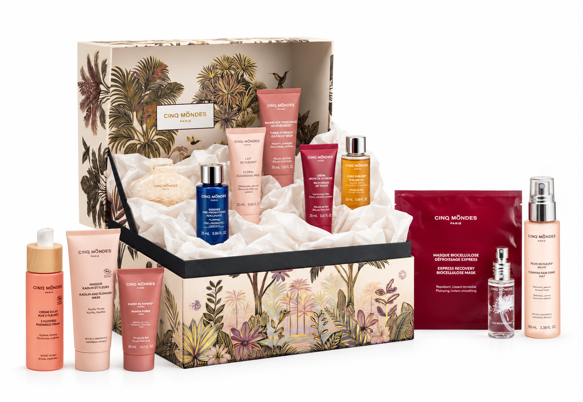 Coffret cadeau Les Pharmacopées Cinq Mondes ouvert, avec ses soins visage et corps présentés dans du papier de soie blanc.